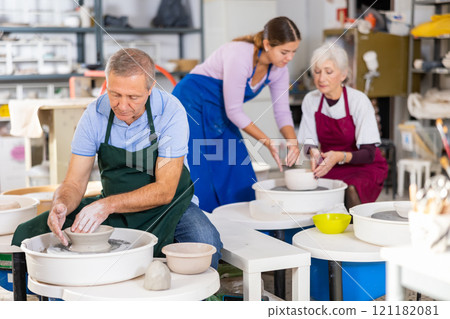 potter works on potter's wheel 121182081