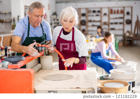 potter works with student machine clay press roller 121182229