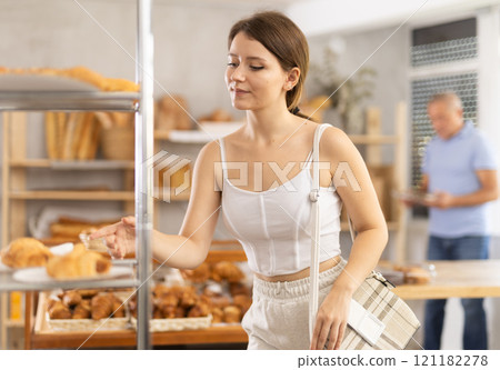 Young woman buyer chooses pastries in bakery 121182278