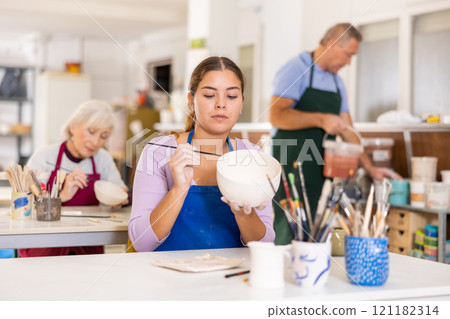 woman paints vase that she made herself woman paints vase that she made herself 121182314