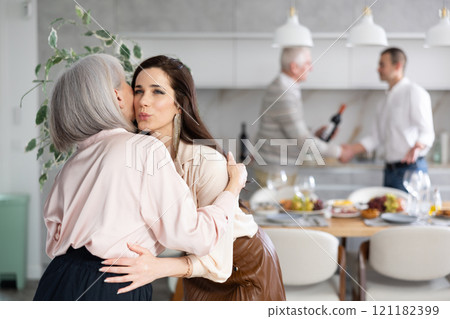 Happy young woman welcoming old lady at home 121182399
