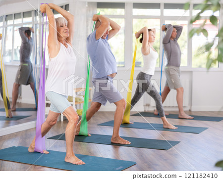 Elderly woman exercises with pilates band 121182410