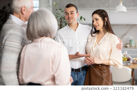 Happy young man and woman welcoming their senior parents at home Happy young man and woman welcoming their senior parents at home 121182479