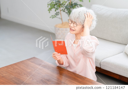 Senior woman checking her pension book 121184147