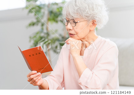 Senior woman checking her pension book 121184149