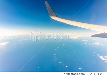 View from the airplane window at a beautiful blue clear sky and the airplane wing View from the airplane window at a beautiful blue clear sky and the airplane wing 121184346