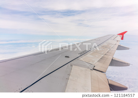 View from the airplane window at a beautiful cloudy sky and the airplane wing View from the airplane window at a beautiful cloudy sky and the airplane wing 121184557