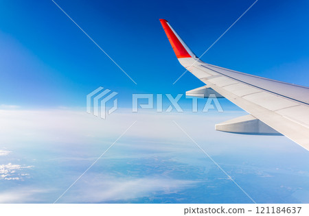View from the airplane window at a beautiful cloudy sky and the airplane wing 121184637