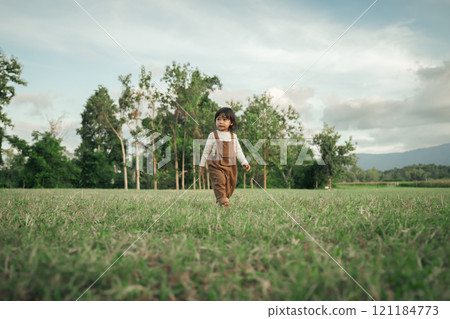 happy toddle baby girl walking on grass field happy toddle baby girl walking on grass field 121184773