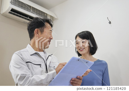 A woman happy with an estimate for air conditioner repair 121185420