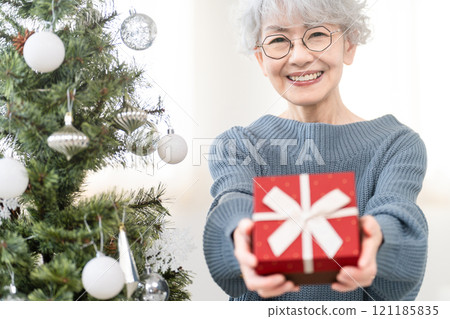 拿著聖誕禮物的資深婦女 拿著聖誕禮物的資深婦女 121185835