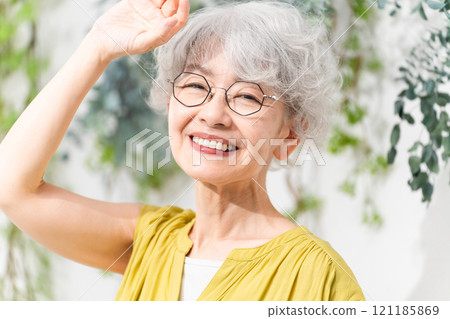 Senior woman wearing a yellow dress 121185869