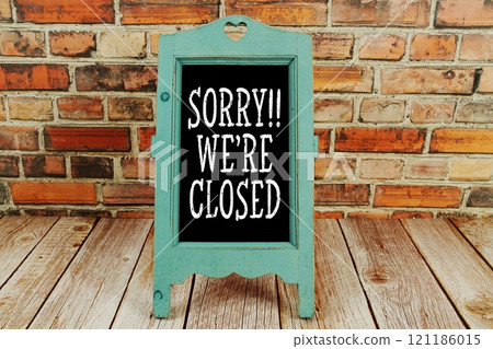 Sorry We're Close text on blackboard with easel stand on wooden and old brick wall background Sorry We're Close text on blackboard with easel stand on wooden and old brick wall background 121186015