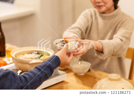 冬夜，一對中年夫妻在客廳享用火鍋晚餐 121186271