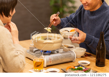 冬夜，一對中年夫妻在客廳享用火鍋晚餐 121186275