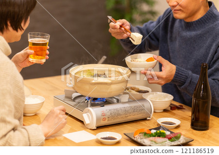 冬夜，一對中年夫妻在客廳享用火鍋晚餐 121186519