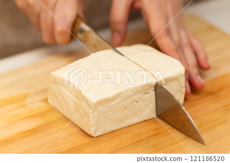 一位中年婦女的手在切板上切硬豆腐 121186520