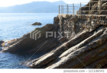 Sea and rock with walkway for tourists. Panorama and relaxation. Sunny day and calm. Sea and rock with walkway for tourists. Panorama and relaxation. Sunny day and calm. 121186541
