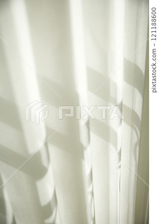 A minimalist interior in wood tones with warm sunlight streaming in. 121188600