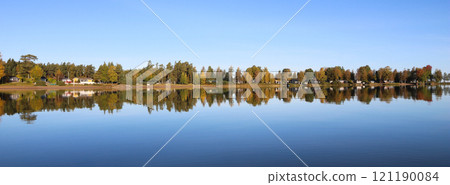Calm autumn day, colorful trees reflecting in Lake Vanern, Sweden. 121190084