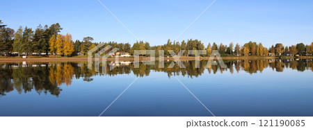 Golden autumn forest reflecting in Lake Vanern, Sweden. 121190085