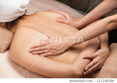 A young Asian woman is getting a back oil massage. 121190166