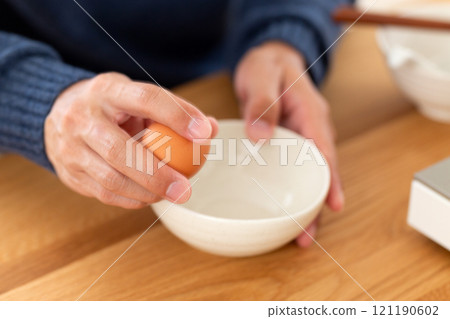 一名中年男子的手打破生雞蛋 121190602