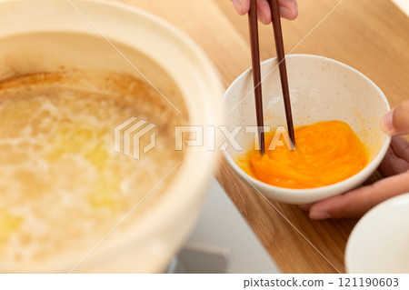 一名男子用雞鍋裡剩下的汁煮粥。 一名男子用雞鍋裡剩下的汁煮粥。 121190603