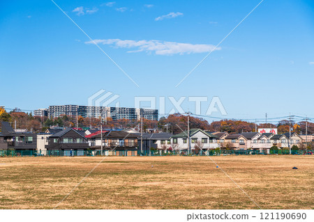 A residential area surrounded by a large park under clear blue skies 121190690