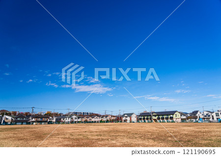 A residential area surrounded by a large park under clear blue skies 121190695