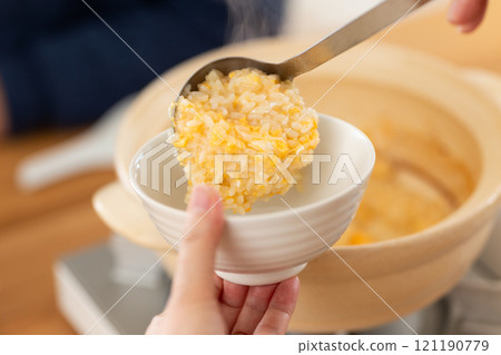 一對中年夫婦享用稀飯和雞湯火鍋 121190779