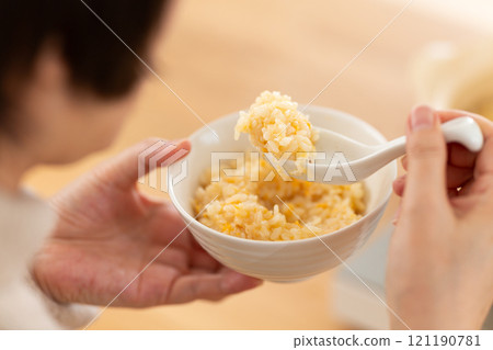 一名中年婦女煮粥並吃完火鍋。 121190781