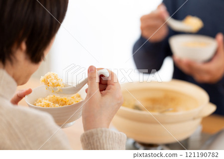 一對中年夫婦享用稀飯和雞湯火鍋 121190782