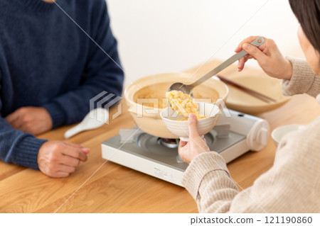 一對中年夫婦享用稀飯和雞湯火鍋 一對中年夫婦享用稀飯和雞湯火鍋 121190860