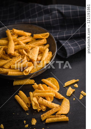 Rolled nachos tortilla chips on black table. Rolled nachos tortilla chips on black table. 121191861