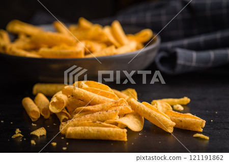 Rolled nachos tortilla chips on black table. Rolled nachos tortilla chips on black table. 121191862