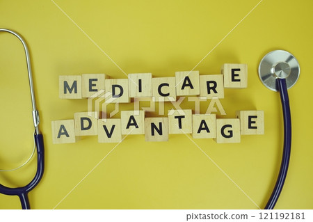 Medicare Advantage with wooden blocks alphabet letters and stethoscope on yellow background 121192181
