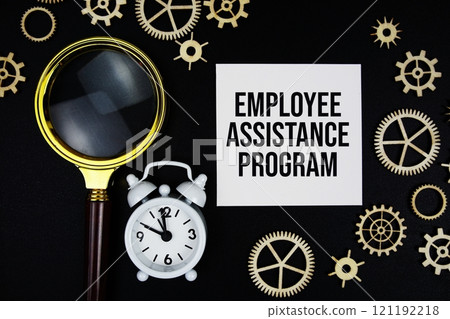 Employee Assistance Program text message on sticky note with magnifying glass and alarm clock on black background 121192218