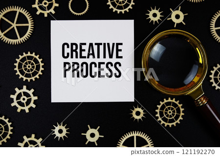 Creative Process text with magnifying glass on black background 121192270