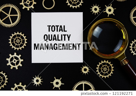 Total Quality Management (TQM) text with magnifying glass on black background 121192271