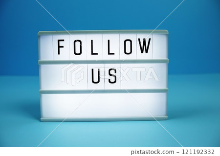 Follow Us letterboard text on LED Lightbox on blue background 121192332