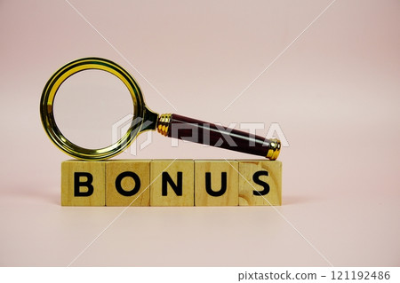Bonus with wooden blocks alphabet letters and Magnifying glass on pink background 121192486