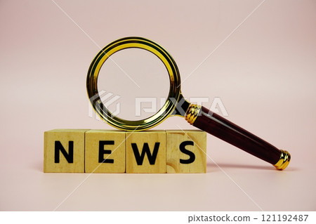 News with wooden blocks alphabet letters and Magnifying glass on pink background 121192487