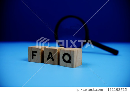 FAQ with wooden blocks alphabet letters and Magnifying glass on blue background 121192715