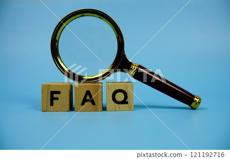 FAQ with wooden blocks alphabet letters and Magnifying glass on blue background 121192716