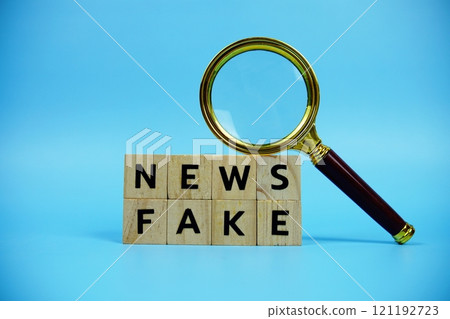 Fake News with wooden blocks alphabet letters and Magnifying glass on blue background Fake News with wooden blocks alphabet letters and Magnifying glass on blue background 121192723
