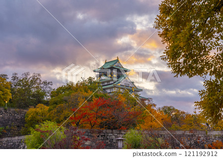 Osaka Castle at dusk, surrounded by autumn leaves 121192912