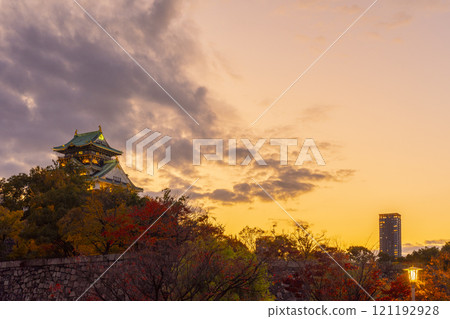 Osaka Castle at dusk, surrounded by autumn leaves 121192928