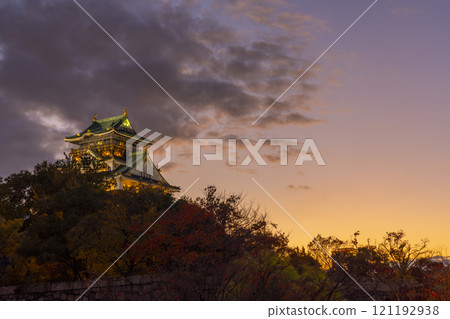 Osaka Castle at dusk, surrounded by autumn leaves 121192938
