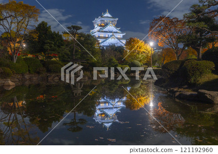 Night view of Osaka Castle's main tower reflected in the pond of Honmaru Japanese Garden 121192960